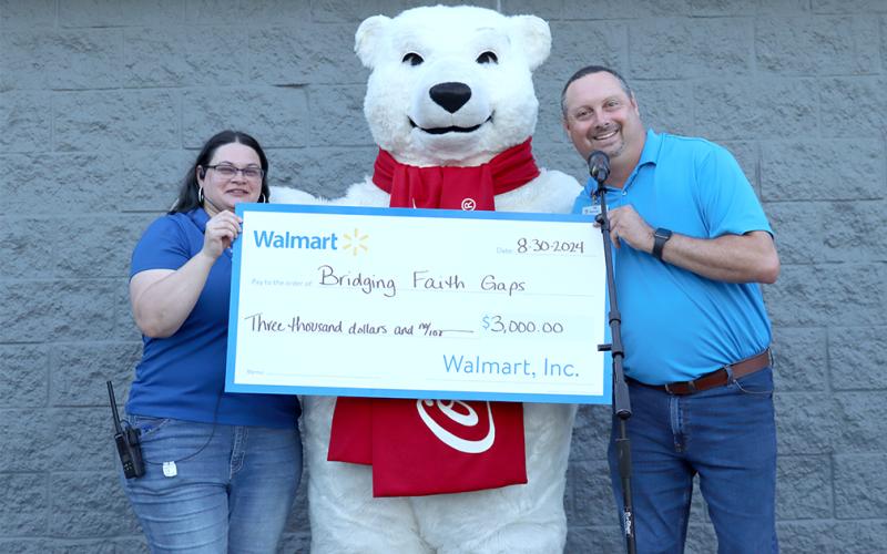 Walmart manager Alan Belford presents donation to Bridging Faith Gaps. (Photo by Weeks)