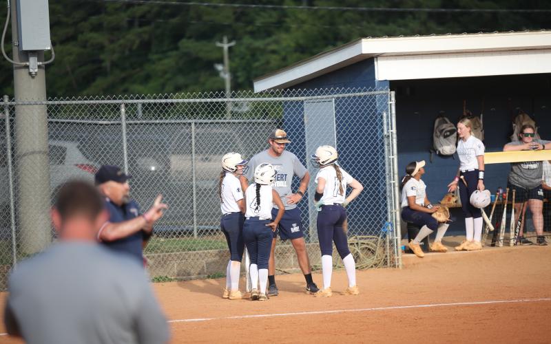Head Coach Bryce Bowen smiles while huddled up with his base runners during a stoppage in play. (Photo by Wells)