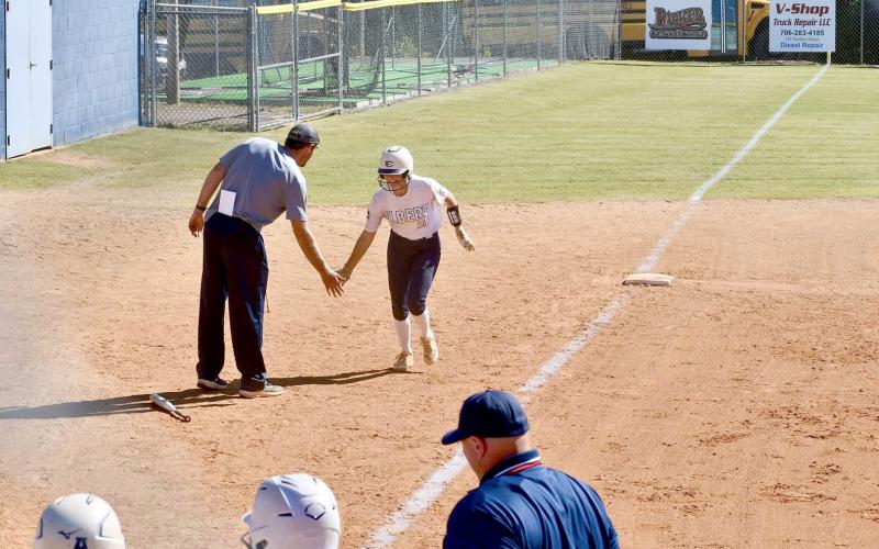 Kamryn Webb high fives Head Coach Bryce Bowen after hitting a three-run home run in Elbert’s second game against Dodge County Oct. 19. (Photo courtesy of Elbert County True Blue)