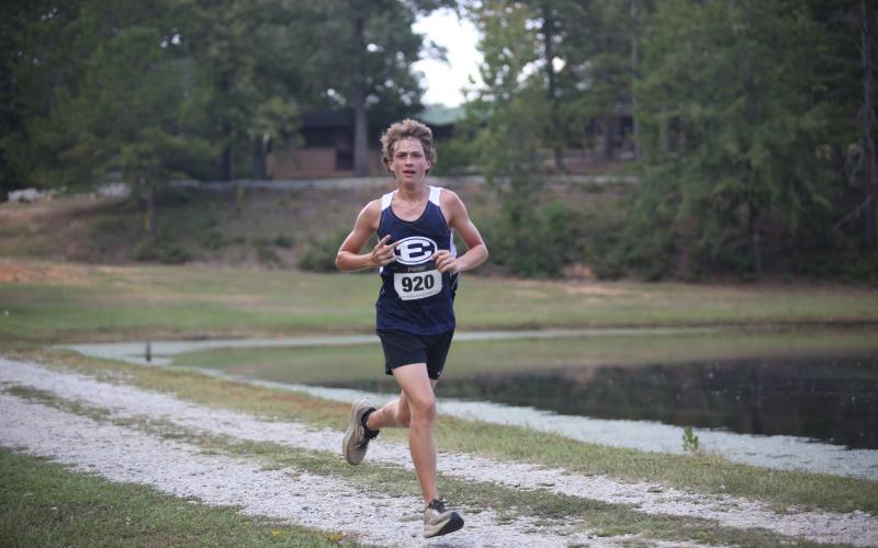 Mitchell Wheeler waves to the camera while they run by during the inaugural Granite City Invitational Sept. 24. (Photo by Wells)