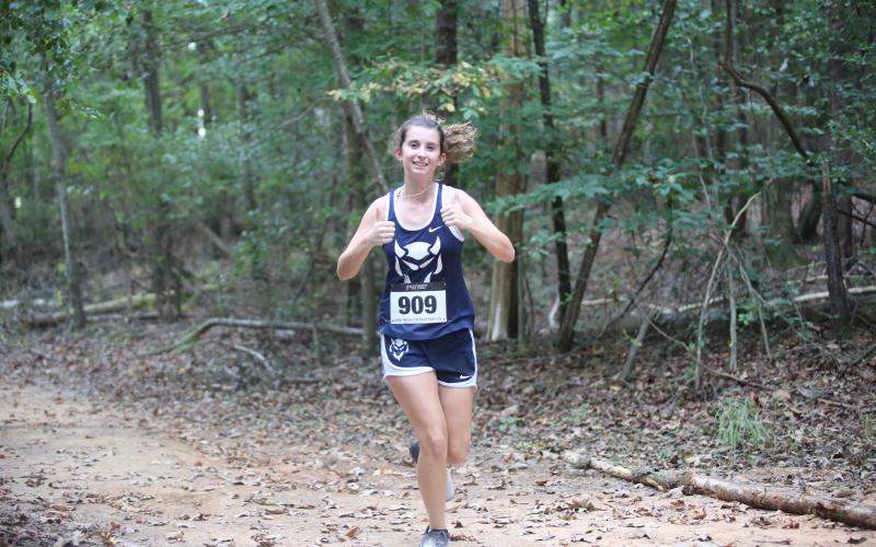 Kennedy Ray waves to the camera while they run by during the inaugural Granite City Invitational Sept. 24. (Photo by Wells)