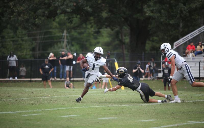 Ty’Rikis Jones pushes a defender aside as he runs with the ball during Elbert’s loss to Commerce. (Photo by Wells)