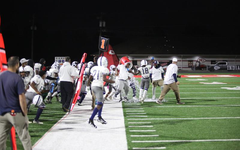 The team showers Coach Stergen Newman with the traditional cooler dump after the victory. (Photo by Wells)