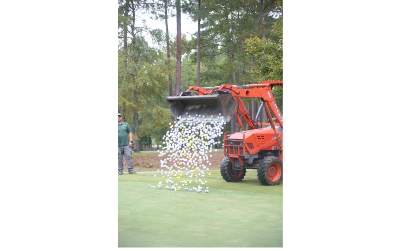 The golf balls are dropped out of a front-end loader for the golf ball drop. (Photo by Mark Wells)