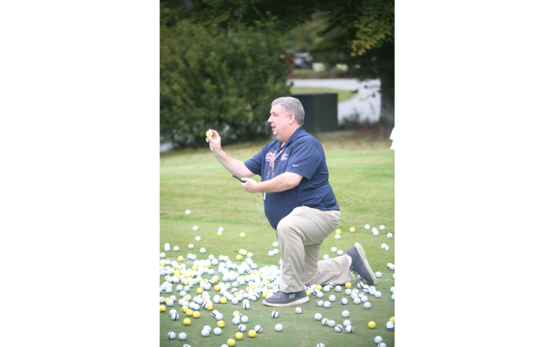 Foundation Chairman Stan Brown holds up the winning ball after pulling it from the bottom of the hole. (Photo by Mark Wells)