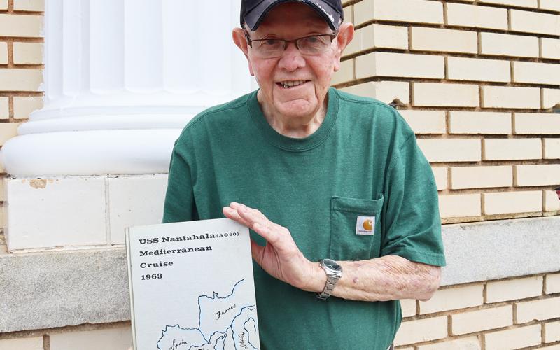 Cone displays the cruise book from his time on the U.S.S. Nantahala. (Photo by Weeks)
