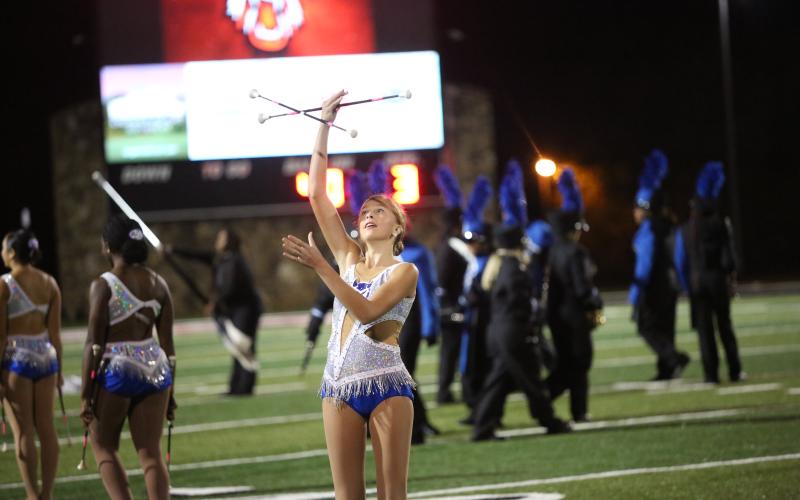 Chansley Brown throws one baton into the air while twirling another during the Elbert County Blue Devil Band’s halftime performance Nov. 1. (Photo by Bethany Booth - Elbert County True Blue)