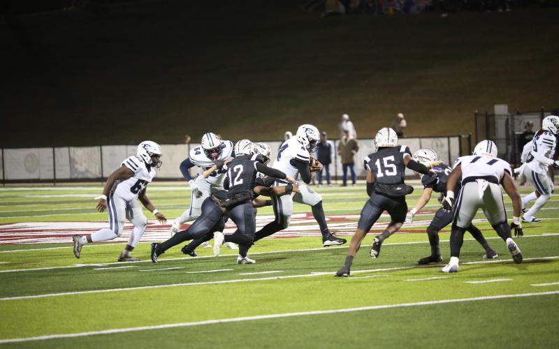 Quarterback Jayvyn Hickman runs through a mass of arm tackles during Elbert’s 26-24 win over Heard County Nov. 22. With the win the Devils advanced to the Elite Eight of the GHSA State Playoffs for the second year in a row. (Photo by Wells)