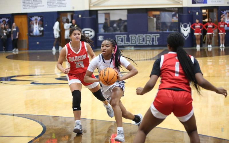 Kaylen Rucker drives through the lane and prepares to attempt a bounce pass to a teammate during Elbert’s 48-40 win over Madison County in the Inferno Dec. 7. (Photo by Wells)