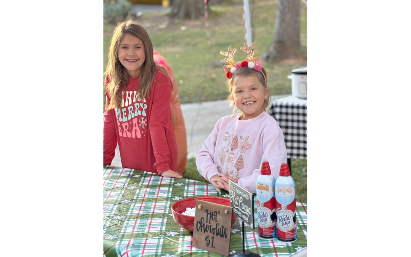 Brylee (L) and Bria (R) Dickerson set up a hot chocolate stand in their neighborhood Dec. 7 and raised over $1,000 for a needy family. (Photo submitted by Brooke Dickerson)