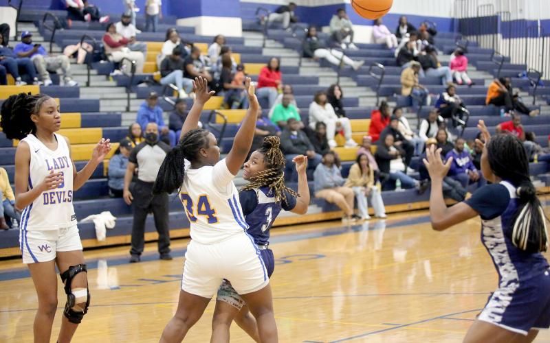 Zoe Evans (left) passes behind her back to Aaliyah Allen (right) during Elbert’s win over Warren County Jan. 18. (Photo by Wells)