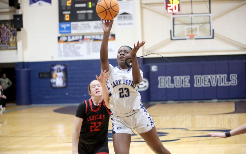 Zy Belcher absorbs contact from a defender and lays the ball into the hoop during the Lady Devils’ win over Rabun. (Photo by Wells)