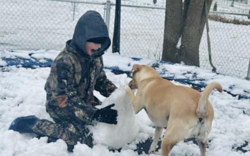 Reed—with help from Mollee—builds a snowman. (Photo submitted by Belinda Thomas)