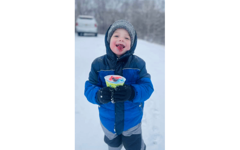 Chandler Truitt enjoys a homemade snow cone with freshly-fallen snow while playing on Springdale Drive during the Jan. 10 Snow Day. (Photo submitted by Kathy Jossey)