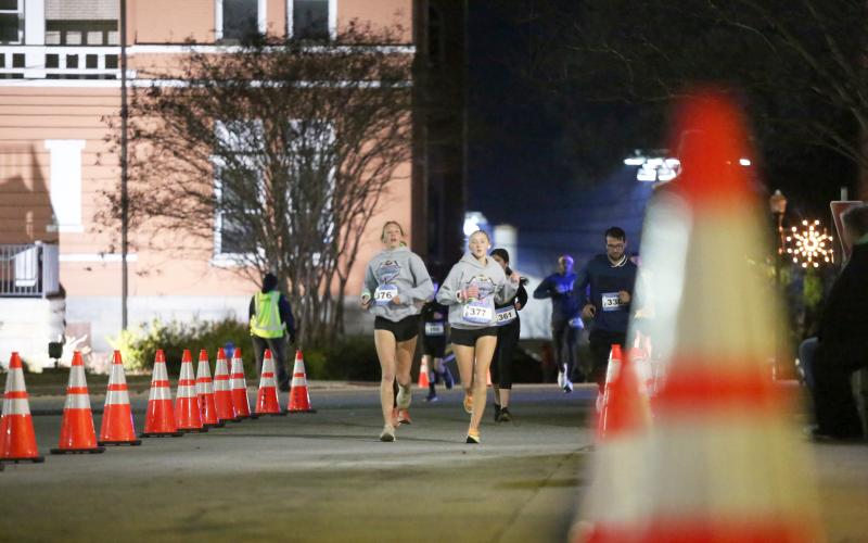Over 100 participants of the 21st annual Twilight Stroll hosted by the Elbert County Chamber of Commerce travel the first leg of the 3.1 mile race in downtown Elberton on Friday, Jan. 3. (Photo by Wells)