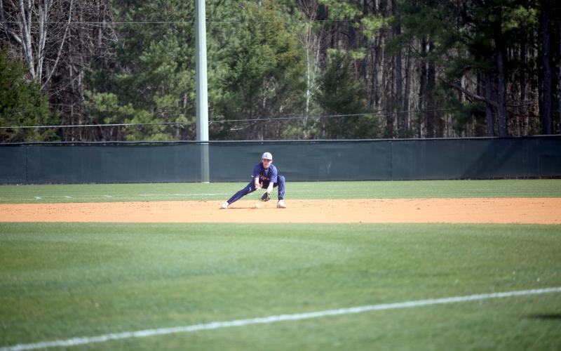 Rylan Brown fields a ground ball before throwing over to first base for an out in the first game of Elbert’s doubleheader on the road against Athens Academy. (Photo by Wells)