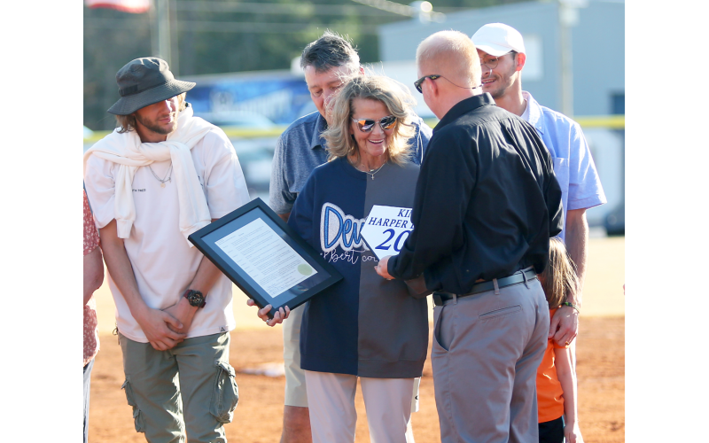 Kim Bray (center) accepts the proclamation and base award from principal Josh Rider signifying the retiring of her ECCHS jersey  while Cole Bray, Tim Bray and Chaz Bray look on. (Photo by Wells)