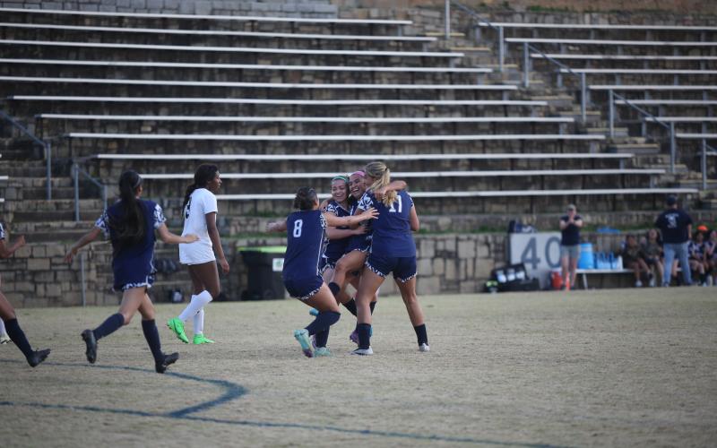 Paulina Guerrero, Carina Medellin, Victoria Medellin and Melanie Badillo celebrate after tying the game up against Commerce March 14. (Photo by Wells)
