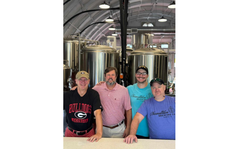 Normaltown Brewing’s majoroity owners Scott Fortson,  David Abernathy, Erich Fietkau and Phil Fortson stand in front of the tanks in the facility on Barber Street in Athens. (Photo submitted by Scott Fortson)