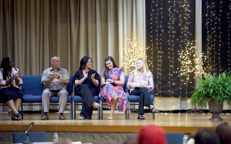 Elbert County Primary School first-grade teacher Meredith Lawson (second from right) learns that she was named district teacher of the year while SFC Daniel Ulrich (far left), Wendy Collier (second from left) and Tina Lunsford (far right) congratulate Lawson during the Elbert County Board of Education's May 19 regular meeting in the Elbert County Middle School auditorium. (Photo by Wells)