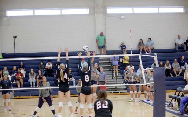 Alexa Vargas carefully tips the ball over the net above a pair of Rabun County opponents. (Photo by Bo Underwood)