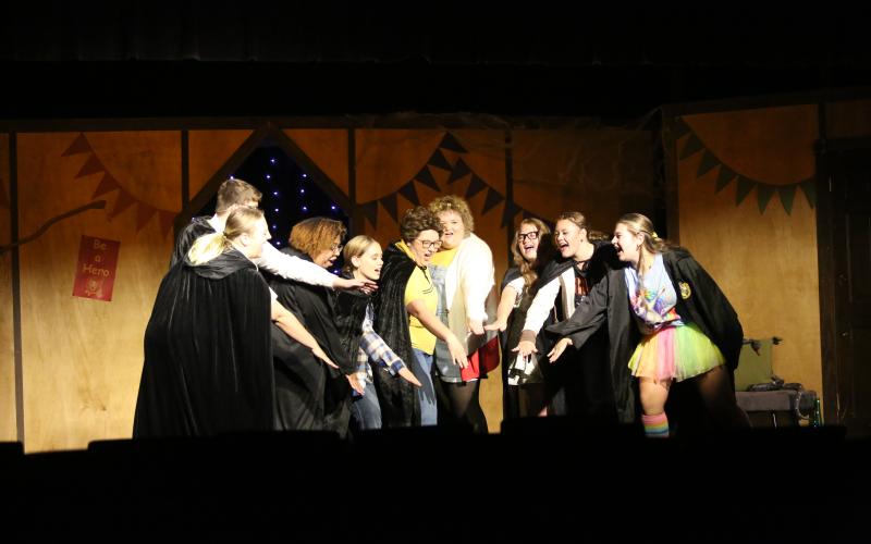 Performers of "Puffs or Seven Increasingly Eventful Years at a Certain School of Magic and Magic" huddle together during a performance at the Elberton Arts Center on August 7. (Photo by Mark Wells)