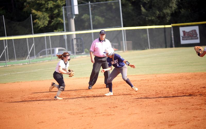 Bellamy Nash tries to freeze the third baseman as she attempts to escape from a pickle during Elbert’s win over Commerce Sept. 18. (Photo by Bo Underwood)