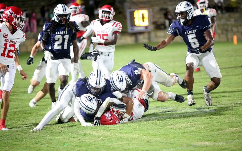A host of Blue Devils brings down the ballcarrier in Elbert’s 24-17 loss to Lincoln on Sept. 12. (Photo by Bo Underwood)