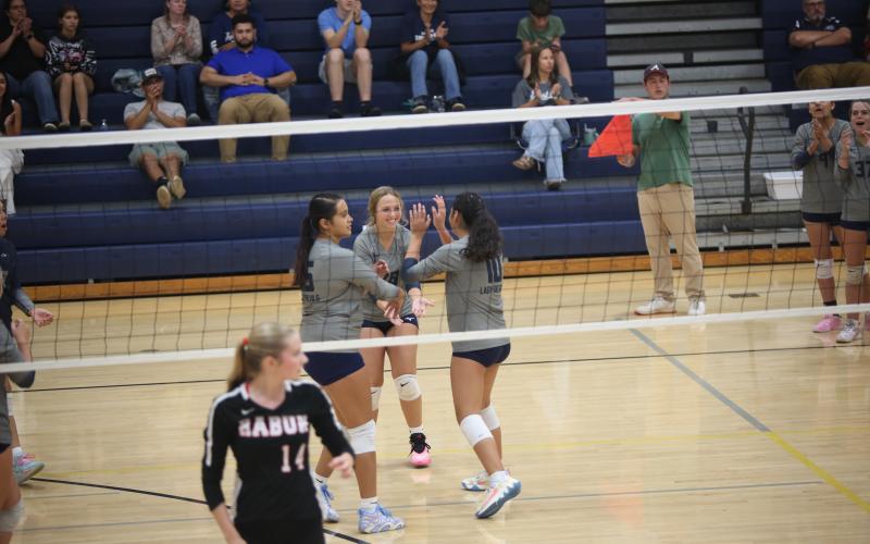 Elbert County teammates Melanie Badillo (left), Ayden Evans (middle) and Alexa Vargas (10) celebrate during their match against Rabun County on Sept. 16. (Photo by Bo Underwood)