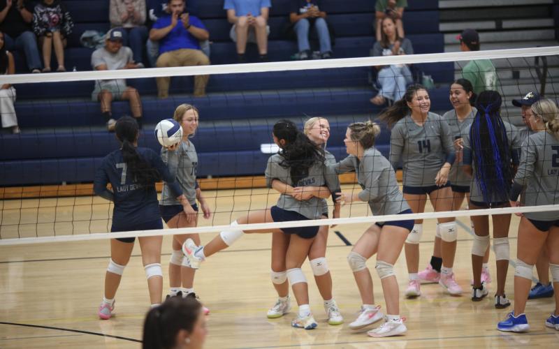 Alexa Vargas (middle left) and Cadence Noggle (middle right) hug after a victory over Rabun on Sept. 16. (Photo by Bo Underwood)