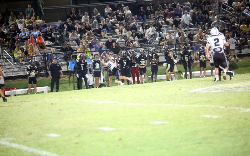 Brycin Hughes (18) makes a diving interception on the sideline. (Photo by Bo Underwood)