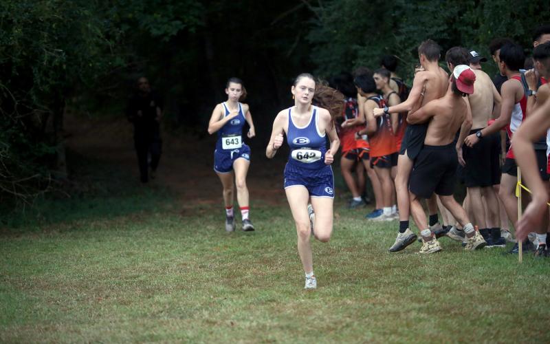 Elbert County runners Kennedy Ray (left) and Marley Geyer (right) run through the woods during the Granite City Invitational. (Photo by Bo Underwood)