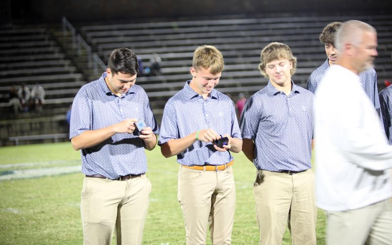 Golfers Nolan Henderson (left) and Madden Drake (right) get their first glimpse of their state championship ring during the ring ceremony for winning the boys Class A Division 1 state championship. (Photo by Bo Underwood)