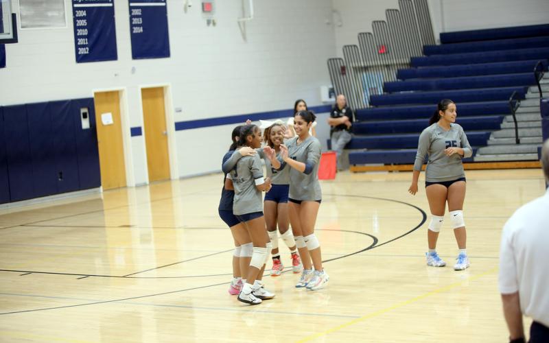 Teammates Anaja Banks (3), Sophia Vargas (blue), Trania Skelton (2) and Alexa Vargas (10) celebrate a point. (Photo by By Underwood)