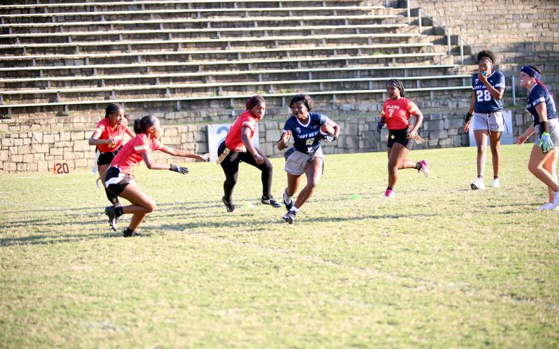 Nakenya Wiley jukes one defender and prepares to evade another during Elbert County's first girls flag football game in the Granite Bowl. (Photo by Bo Unerwood)
