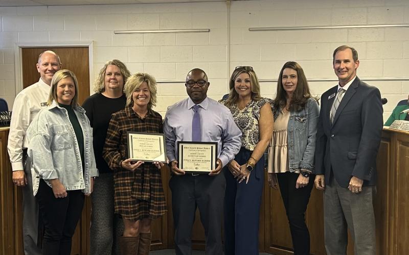 Elbert County Primary School principal Christy Hart and Elementary School principal Jasper Huff accept certificates from the board of education for their schools being designated as Title I reward schools. (Photo by Bo Underwood)