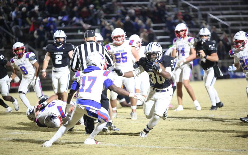 Petey Allen (30) stiff-arms a defender in Elbert’s 24-7 playoff win over Oglethorpe on Nov. 14. (Photo by Bo Underwood)