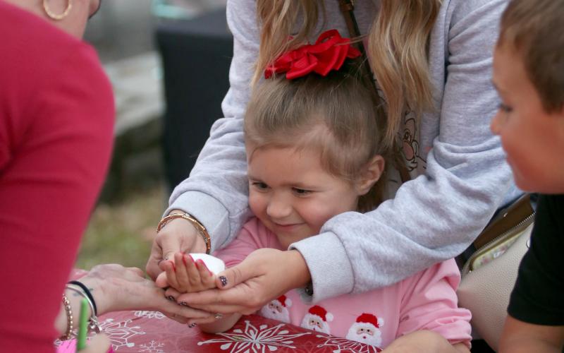 A young girl interacts with a vendor  at Elberton's Candlelight Shop Night on Nov. 25. (Photo by Mark Wells)