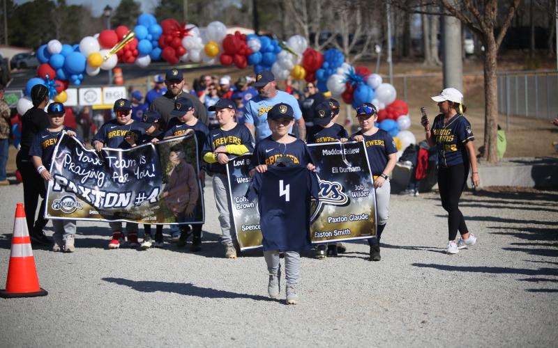 In one of the most emotional moments of 2025, Paxton Glaude's Brewers teammates walk with his jersey as a sign of support after Glaude was forced to miss Elbert County Little League's Opening Day ceremonies after he was involved in a motor vehicle accident. (File Photo by Mark Wells)