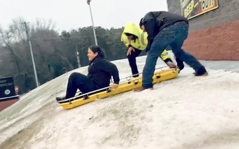 Elbert County Emergency Services personnel use a back board as an improvised sled in between calls during Winter Storm Fern. (Photo submitted by Beth Seymour)