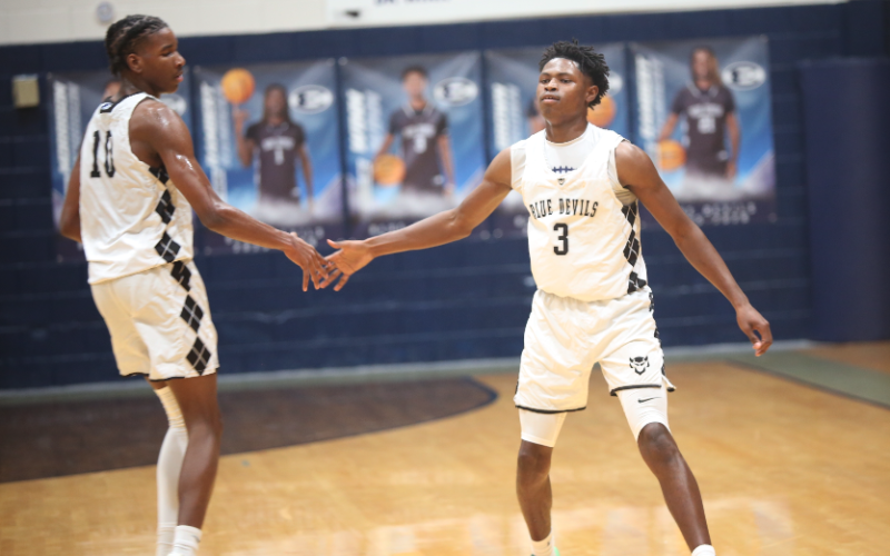 Winn high-fives teammate A.J. Brown after making a basket. (Photo by Bo Underwood)