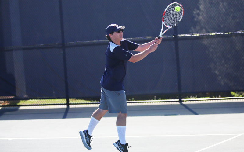 Adrian Jenkins returns a serve with two hands. (Photo by Bo Underwood)