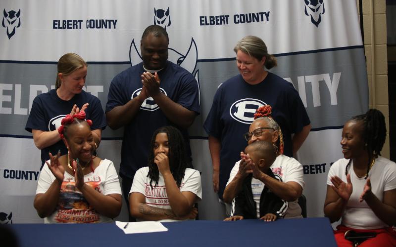 Zoe Evans (bottom row, second from left) signs her letter of intent to play flag football at Emmanuel University. Evans was joined by (bottom row from right:) godmother Tanya Allen, brother Ezequiel Calhoun, mother Davasia McLendon and grandmother Debbie Carpenter. (top row from right:) ECCHS flag football head coach Ashley Bryant and assistant coaches A.J. German and Sarah Navarro.