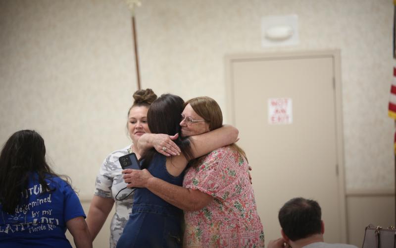 Terri Jackson receives a hug after completing Mother to Mother's 12-month recovery course. (Photo by Mark Wells)