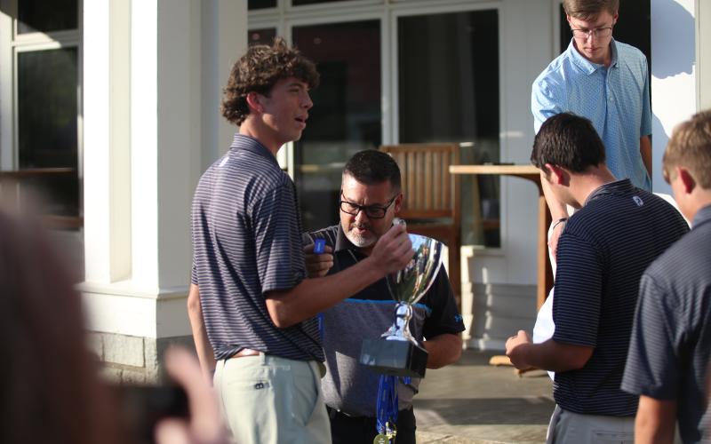 Landen Adams receives the state championship trophy. (Photo by Bo Underwood)