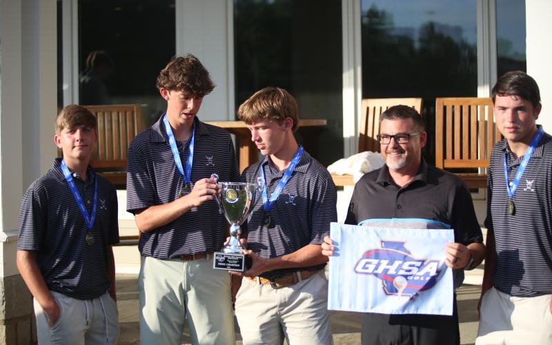 Elbert County golfers receive the championship trophy from Arrowhead Pointe Golf Course Manager MJ Wardingley. (Photo by Bo Underwood)
