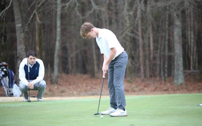 Nolan Henderson watches as Madden Drake putts. (Photo by Bo Underwood)