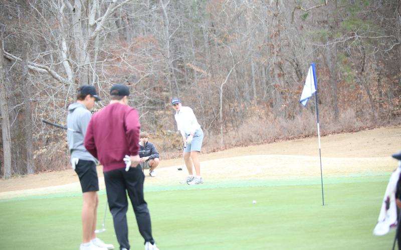 Ty Johnson putts as Carson Amabile looks on. (Photo by Bo Underwood)