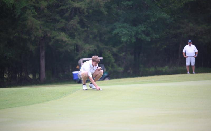 Madden Drake marks his ball on the green. (Photo by Bo Underwood)