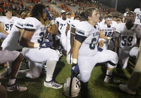 Blue Devils (L-R) Tamar Burton, Seth Capps and A.J. German take a knee to listen to head coach Brad Waggoner after losing to Hart County Friday night Aug. 23 in Hartwell. (Photo by Cary Best)